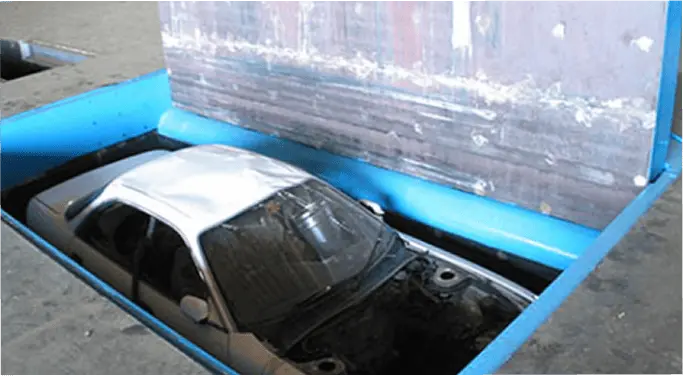 解体用のプレス機に乗せられた車両が潰される直前の状態