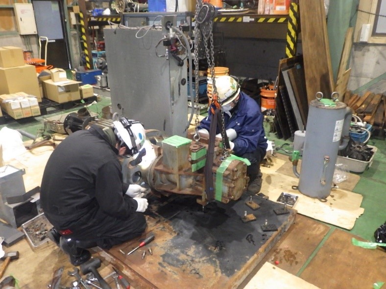 圧縮機を整備している作業員